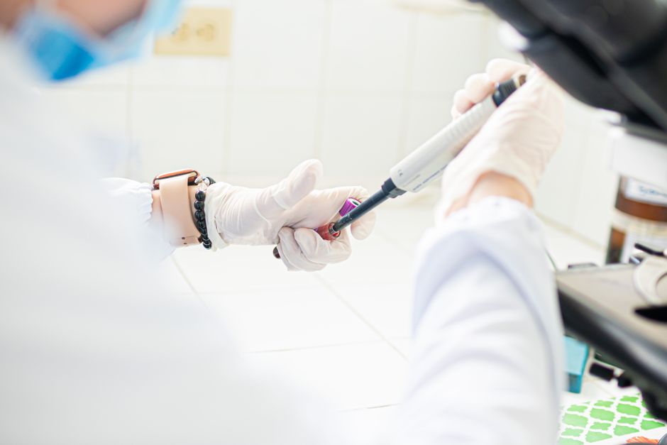 A medical professional using pipette in a lab setting, emphasizing precision and care.