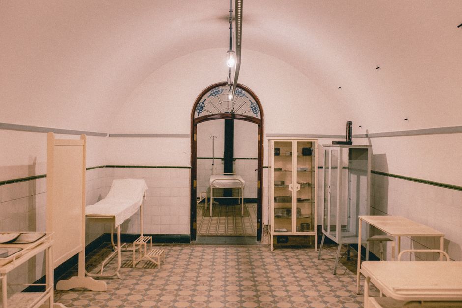 An old-fashioned hospital room with vintage medical furniture and equipment, evoking a retro clinical atmosphere.